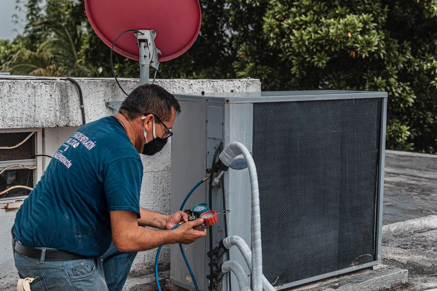 Technician checking system pressure and airflow with a manifold gauge